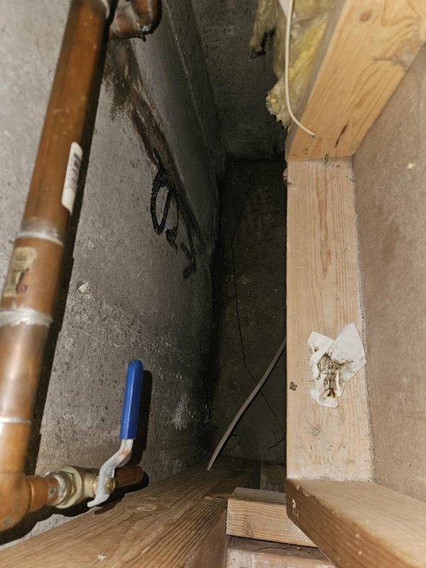 Responded to report of water seepage through foundation wall into basement causing carpet damage. Inspected basement plumbing system including copper supply lines with ball valve shut-off at foundation wall area. Investigated exterior irrigation system and located underground valve box containing solenoid valve assembly with multiple zone controls. Determined water intrusion was related to irrigation system malfunction rather than interior plumbing fixture failure. Assessed valve box condition showing signs of weathering, sediment accumulation, and potential valve leakage contributing to moisture migration toward foundation. Recommended irrigation system repairs to address seepage issue and prevent further water damage to basement area.