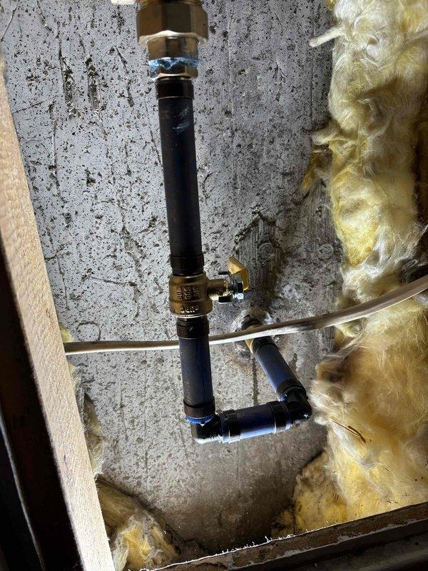 Responded to no hot water issue at basement shower. Upon inspection, determined shower valve was faulty and preventing hot water flow to fixture while rest of house had proper hot water supply. Replaced defective shower valve with new brass valve assembly, reconnecting supply lines and securing installation between floor joists. During troubleshooting process, main water shutoff to house was required, at which time discovered minor leak at main shutoff valve. Tested system after valve replacement and confirmed hot water now flowing properly to basement shower. All connections secured and installation verified operational.