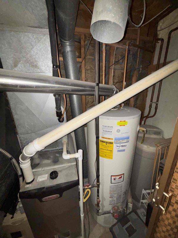 Responded to urgent no-cooling call on 22-year-old residential central air conditioning system. Upon inspection, diagnosed failed capacitor and severely clogged evaporator coil as primary issues preventing system operation. Unit had been shut down to prevent compressor damage. Documented existing furnace and AC configuration in easily accessible basement utility area, including ductwork layout and equipment specifications. Provided comprehensive estimate for capacitor replacement and coil cleaning services to restore cooling functionality.