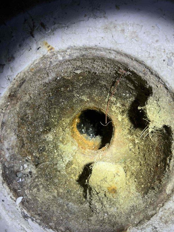 Responded to slow-draining fixture with significant mineral buildup and sediment accumulation in drain basin. Performed drain cleaning service to clear obstruction and restore proper flow, removing accumulated debris, rust deposits, and crusty mineral scaling from drain opening and interior surfaces. This service was necessary as a follow-up to recent tankless water heater and water softener installation to prevent potential basement flooding and allow for safe activation of the new water softener system.
