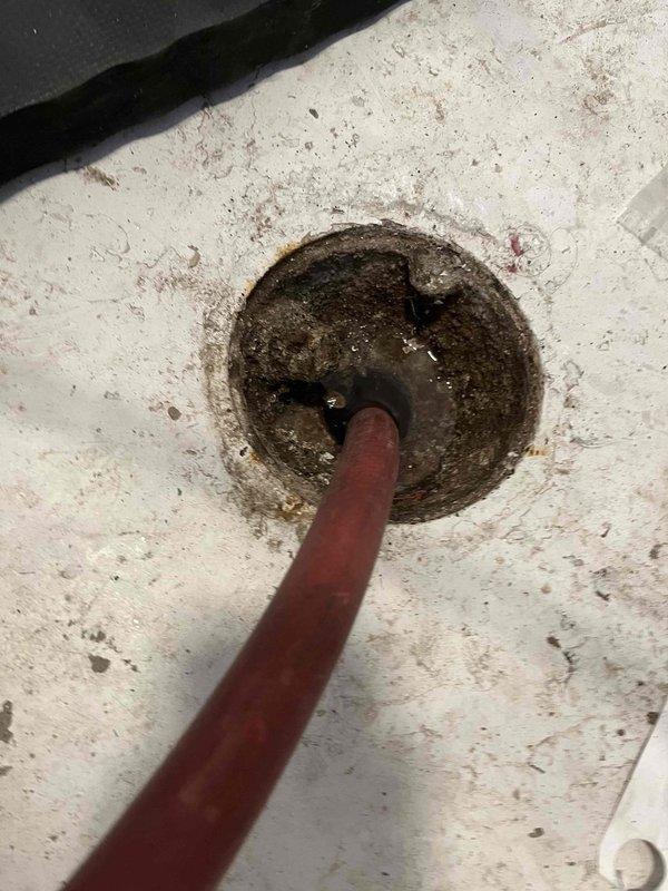 Responded to slow-draining fixture with significant mineral buildup and sediment accumulation in drain basin. Performed drain cleaning service to clear obstruction and restore proper flow, removing accumulated debris, rust deposits, and crusty mineral scaling from drain opening and interior surfaces. This service was necessary as a follow-up to recent tankless water heater and water softener installation to prevent potential basement flooding and allow for safe activation of the new water softener system.