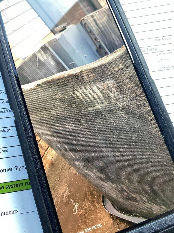 Responded to no-cooling call on 18+ year old single-zone residential air conditioning system with condenser located on back porch and furnace on main level. Upon inspection, found severely clogged condenser coil with heavy dirt and debris accumulation restricting airflow, and extremely dirty air filter with significant particulate buildup causing reduced system airflow. Performed Cool 10+ preventive maintenance including condenser coil cleaning, replaced air filter, checked refrigerant pressures and temperatures, verified amperage draw on compressor and condenser fan motor, and confirmed proper system operation with adequate subcooling levels upon completion.