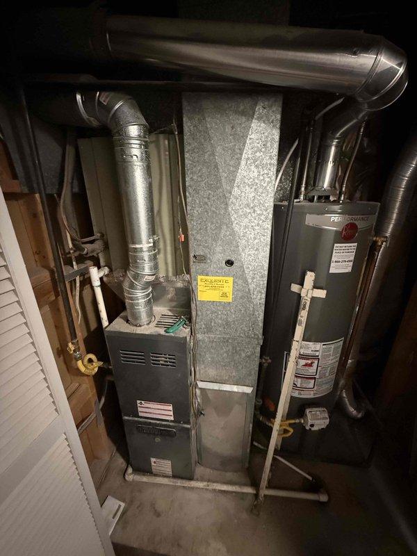Responded to no cooling complaint on residential split system with outdoor condensing unit and basement furnace. Performed comprehensive Cool 10+ preventive maintenance inspection including visual assessment of indoor air handler, ductwork connections, and mechanical room components. Inspected furnace cabinet, verified proper flue pipe installation, and examined air filtration system. Evaluated condensate drainage pathways and checked for proper insulation on refrigerant lines in confined access areas. Documented equipment condition with photos showing Performance-branded water heater adjacent to HVAC system, metallic supply ductwork, and copper refrigerant piping. Verified system operation and restored cooling functionality to residential comfort system.