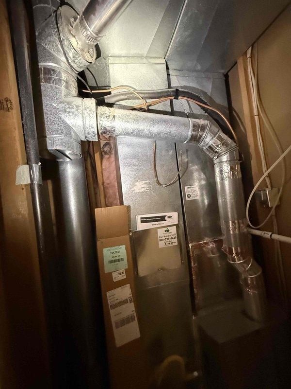 Completed full residential HVAC system installation featuring a Carrier furnace unit with associated ductwork, venting, and drainage systems. Installation included rigid and flexible metal ductwork configuration, black exhaust piping, white PVC condensate drain lines, and all necessary electrical connections. System was installed in utility area, tested, and left operational per specifications.