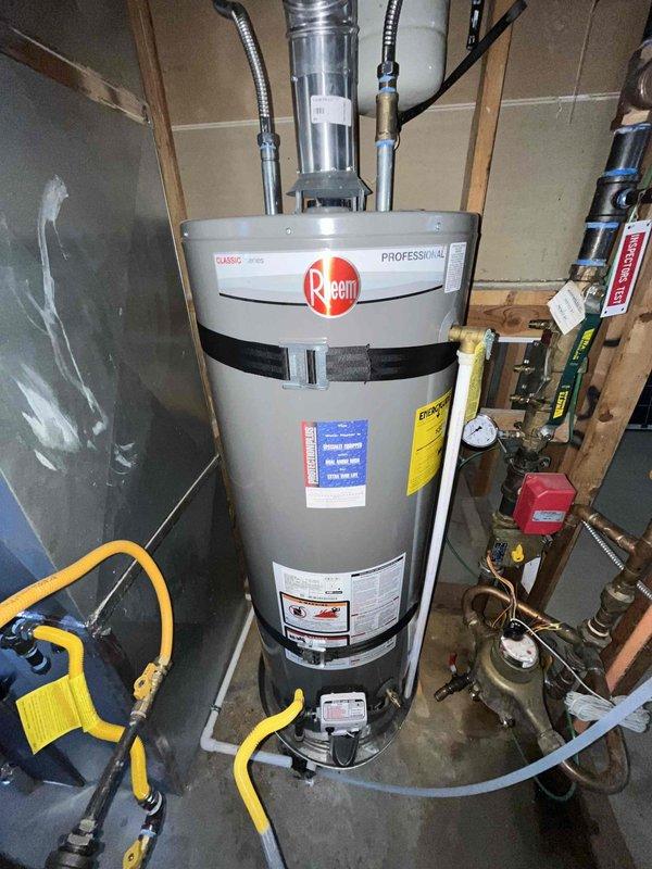 Responded to service call for 4-month-old Rheem Professional tanked water heater with flashing indicator light. Performed diagnostic inspection of unit installed in basement with proper seismic strapping and venting. Verified all operational parameters including gas supply, burner operation, temperature and pressure relief valve function, and flue venting system. Inspected electrical connections and control board status. Confirmed water heater operating within normal specifications with no fault conditions present. Advised that intermittent indicator light flash pattern is normal operational status display and does not indicate malfunction. Unit remains under manufacturer warranty with all components functioning properly.