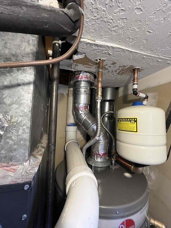 Completed full installation of 50-gallon Rheem water heater in residential utility closet with all code-compliant components including proper venting, thermal expansion tank, earthquake straps, new copper supply lines, and shutoff valve. Removed and disposed of existing unit, installed new water heater with 3/4" PRV and hose bib, tested all connections for leaks, verified proper gas flow and combustion, and confirmed unit operation meets manufacturer specifications.