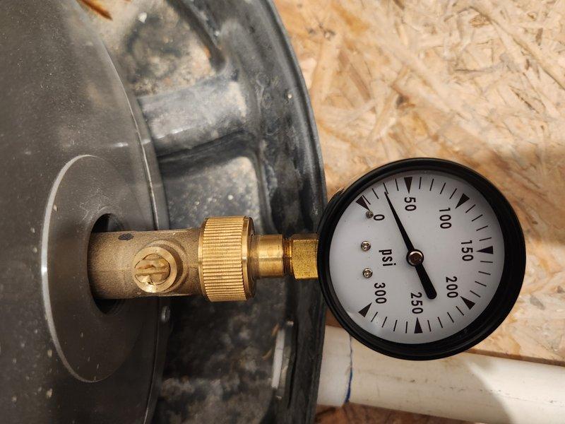 Performed routine maintenance flush on a one-year-old tanked water heater located in the garage. Drained sediment buildup from tank, verified pressure relief valve operation at 0 psi static reading, and inspected all plumbing connections and shut-off valves for proper function and leaks. System restored to normal operation with all components functioning as designed.