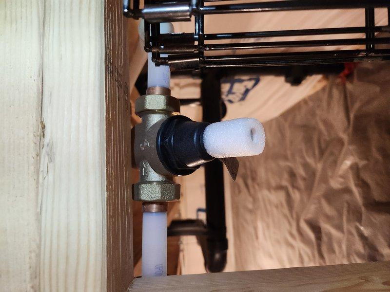 Performed routine maintenance flush on a one-year-old tanked water heater located in the garage. Drained sediment buildup from tank, verified pressure relief valve operation at 0 psi static reading, and inspected all plumbing connections and shut-off valves for proper function and leaks. System restored to normal operation with all components functioning as designed.