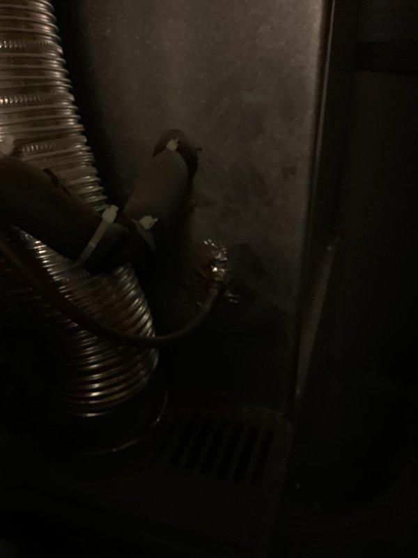 Responded to no-cooling complaint on 10+ year old single-zone air conditioning system with outdoor unit located at rear of property and air handler in basement. Upon arrival, performed diagnostic evaluation of system that was completely inoperative with no power to thermostat or equipment. Inspected electrical connections, refrigerant lines, condensate drainage, and ductwork in basement mechanical space. Documented existing equipment condition and installation configuration with photographic evidence showing refrigerant piping, flexible ductwork routing, and overhead plenum construction.