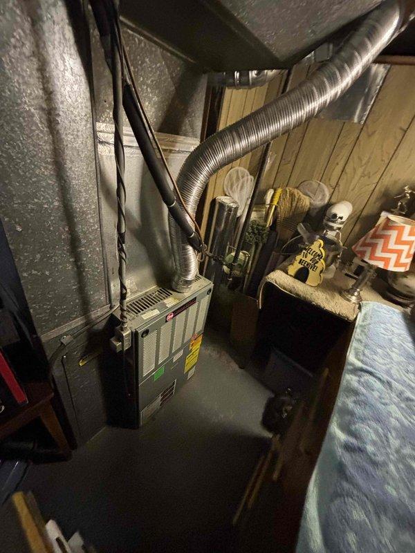 Responded to no-cooling call on a 25-year-old residential HVAC system with AC unit located at rear of property and furnace in basement. Upon diagnostic evaluation, determined system had complete refrigerant loss and was operating beyond serviceable life expectancy. Assessed existing equipment condition, ductwork configuration, and installation requirements. Provided comprehensive estimate for full system replacement, presenting options ranging from standard efficiency to high-efficiency equipment configurations. Documented existing basement furnace installation with metallic ductwork and insulation setup for replacement planning purposes.