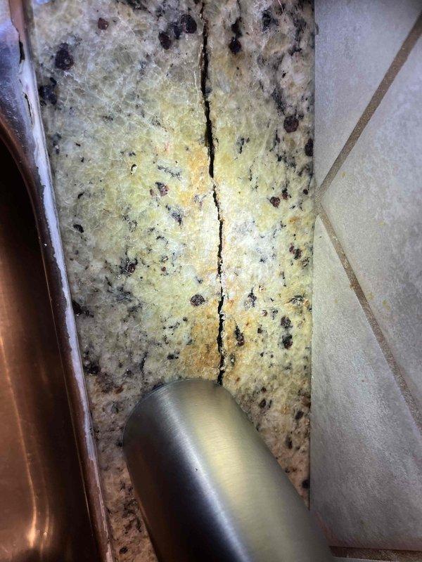 Responded to service call for loose kitchen faucet in main floor kitchen. Upon inspection, diagnosed issue as unsecured mounting rod that had come loose approximately one year after initial installation. Tightened and secured the mounting rod to restore proper faucet stability and function. During inspection, identified crack in granite countertop near faucet base that was contributing to fixture instability. Provided recommendations for sealing countertop crack and advised consulting countertop specialist for permanent repair. Additionally performed courtesy inspection of toilet experiencing intermittent refilling issues. Suspected minor internal leak, likely flapper or fill valve malfunction, and provided homeowner with instructions for performing dye test using food coloring to confirm leak source. Offered to return for flapper replacement if testing confirmed leak.
