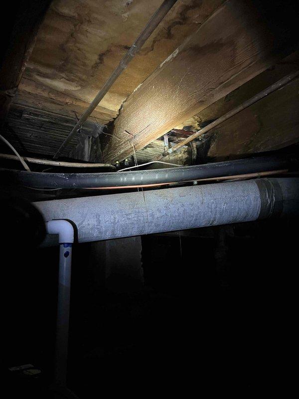 Responded to a burst pipe emergency in the crawlspace where a corroded pipe was actively leaking and spraying water upward. Accessed the crawlspace, located the failed section of corroded piping among the floor joists and existing utility lines, and replaced the damaged pipe section to restore water service and prevent structural damage to the home.