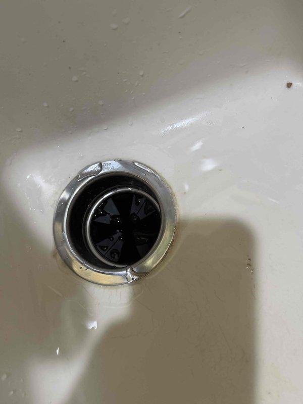 Responded to service call for non-functional garbage disposal unit. Upon inspection, found 20-year-old disposal with severely corroded mounting assembly and deteriorated drain connections showing extensive rust and oxidation. Assessed existing sink drain fixture and disposal mounting hardware, noting significant mineral deposits and age-related deterioration throughout the system. Provided quote for complete disposal replacement including new mounting assembly and drain connections to restore proper functionality.