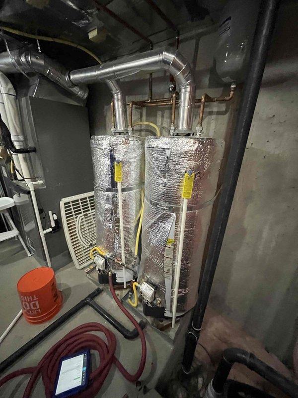 Performed routine maintenance flush on tanked water heater system. Inspected dual water heater installation with reflective insulation wrapping, verified all connections, valves, and piping for proper operation. Confirmed expansion tanks, copper supply lines, and associated HVAC ductwork in mechanical room are functioning correctly with no visible leaks or issues detected.