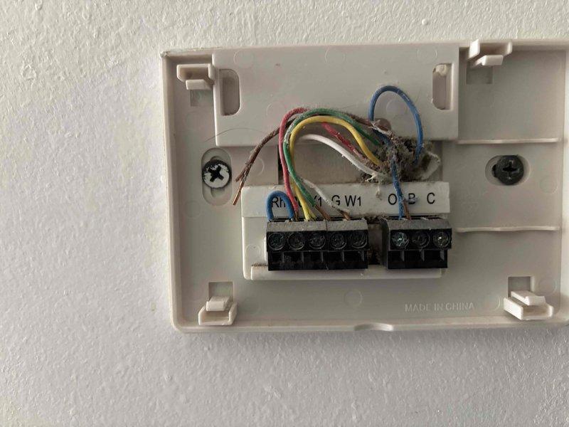 Responded to no-cooling call on residential split system. Upon arrival, verified outdoor unit was not receiving power and indoor system was unresponsive to thermostat commands. Inspected thermostat wiring at wall-mounted control, found loose connections at terminal block affecting multiple low-voltage circuits including R, Y, G, and C wires. Accessed crawl space to inspect furnace and associated wiring, verified proper installation of insulated ductwork and copper refrigerant lines. Tightened all thermostat terminal connections, restored proper wire seating at control board, and cycled system through heating and cooling modes to confirm restoration of functionality. Unit now operating normally with proper communication between thermostat and equipment.
