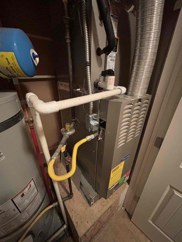 Evaluated 30-year-old residential HVAC system experiencing cooling failure with air handler operational but no refrigeration. Documented existing equipment configuration including furnace, ductwork, gas line, PVC drainage, and associated mechanical components in utility closet. Provided complete system replacement estimate due to age of equipment and loss of cooling capacity.