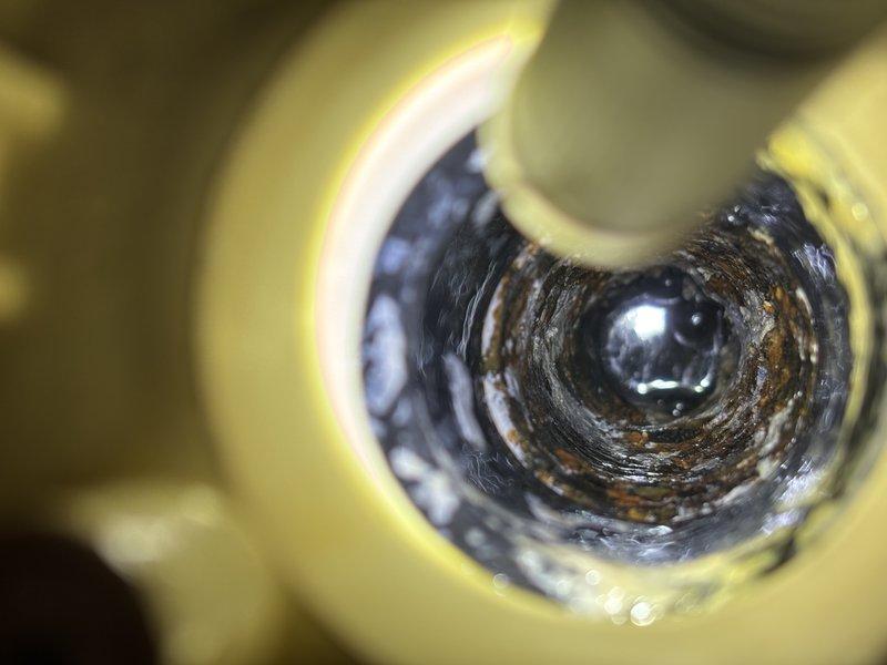 Responded to a completely backed-up basement shower drain. Upon inspection, found significant mineral deposits, soap scum, and sediment buildup within the SCH 40 PVC drain assembly, causing severe flow restriction. Cleared the obstruction and restored proper drainage to the fixture.