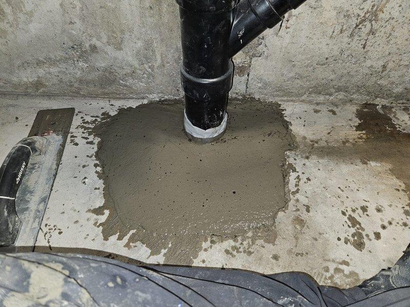 Jackhammered and removed concrete around the base of the main stack to access deteriorated plumbing beneath the slab. Rebuilt and repiped the bottom section of the stack, including the laundry drain connection and 90-degree fitting assembly under the concrete floor. Restored concrete to original grade upon completion of the underground plumbing repairs.