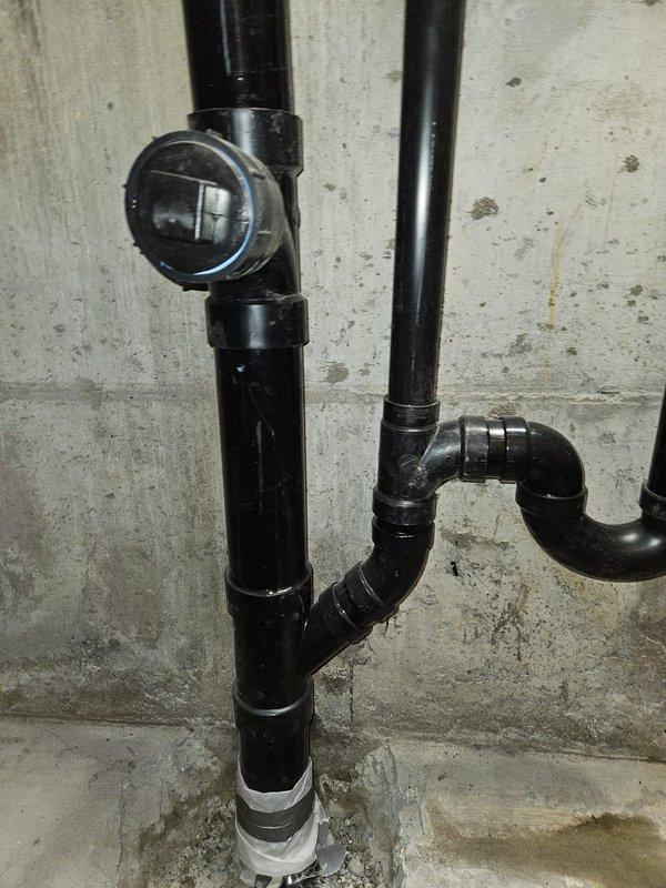 Jackhammered and removed concrete around the base of the main stack to access deteriorated plumbing beneath the slab. Rebuilt and repiped the bottom section of the stack, including the laundry drain connection and 90-degree fitting assembly under the concrete floor. Restored concrete to original grade upon completion of the underground plumbing repairs.