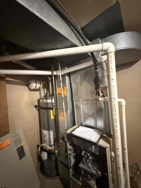 Responded to service call for air conditioning system not cooling properly with reported squeaking noise. Upon inspection, diagnosed failing blower motor and fouled evaporator coil on 2009 system utilizing R22 refrigerant. Presented repair options and full system replacement estimates given age of equipment and obsolete refrigerant type. Documented equipment condition with photographs showing furnace, air handler assembly, and mechanical room installation.