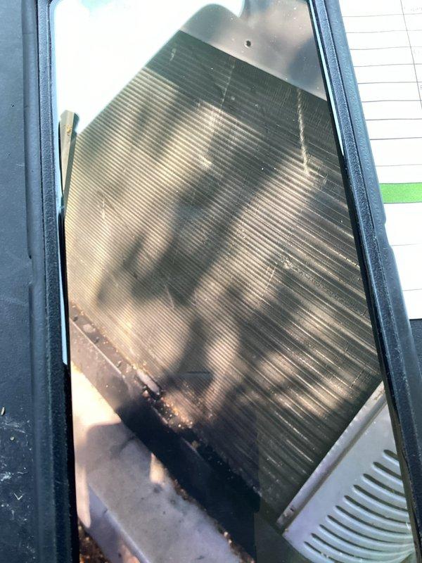 Performed diagnostic service on 5-year-old residential air conditioning system. Inspected outdoor condensing unit and identified severely clogged evaporator coil with extensive dirt accumulation, dark streaking, and debris buildup causing restricted airflow. Filter media found completely saturated with particulate matter requiring immediate replacement. Scheduled return visit for thorough evaporator coil cleaning to restore system efficiency and proper cooling operation.