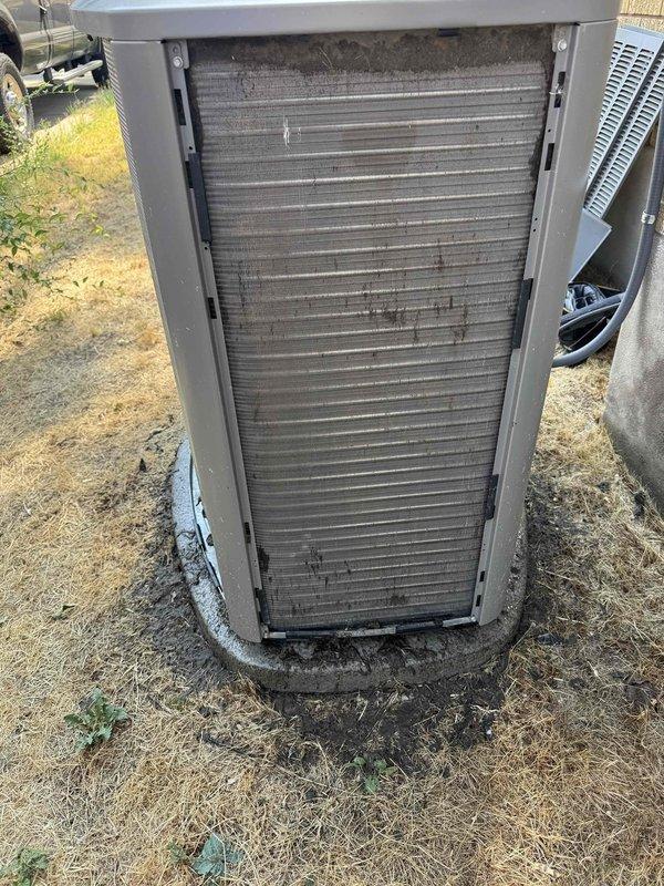 Responded to no-cooling call on residential split system less than one year old. Performed diagnostic inspection on basement-installed furnace and outdoor condensing unit. Found outdoor unit condenser coil heavily soiled with dirt and debris accumulation causing restricted airflow and reduced heat transfer efficiency. Cleaned condenser coil, verified proper refrigerant pressures, and tested system operation. Unit restored to normal cooling function with improved airflow across coil surfaces.