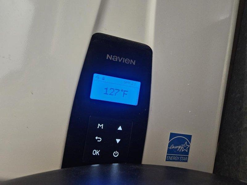 Responded to service call for 1-year-old Navien tankless water heater requiring repeated manual resets to restore hot water operation. Performed diagnostic evaluation of unit control panel displaying 127°F and utilized pressure testing equipment to assess system performance and identify underlying cause of intermittent failure requiring customer intervention to maintain hot water supply.