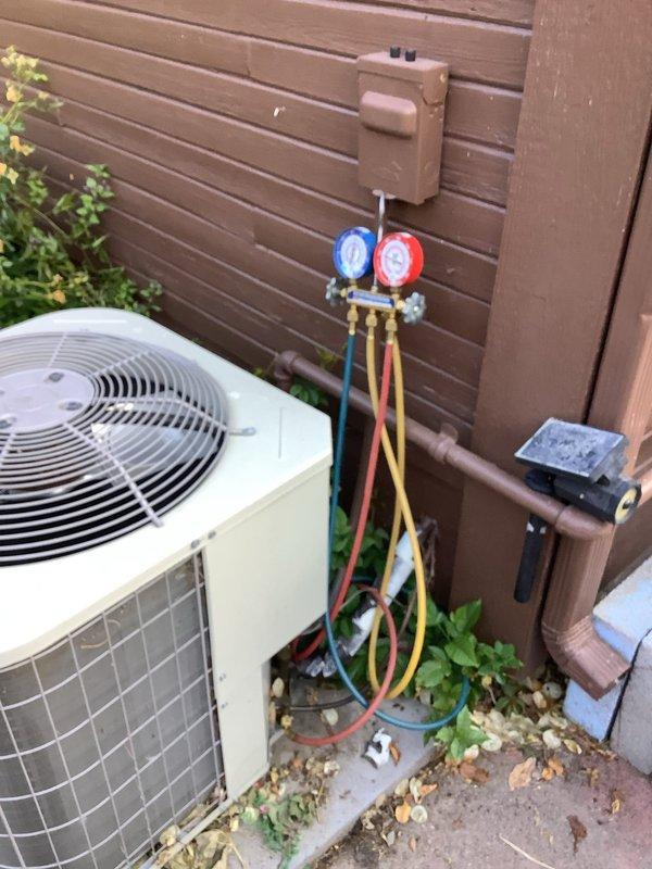 Responded to no cooling complaint on residential split system over 10 years old. Located outdoor condensing unit on side of property and furnace in kitchen area. Connected manifold gauge set to service ports and performed refrigerant pressure diagnostics on the air conditioning system. Inspected attic insulation and ductwork as part of comprehensive system evaluation.