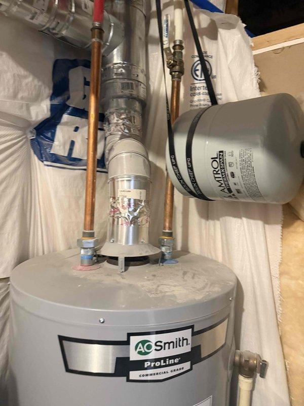Completed annual membership plumbing inspection at residential property. Performed comprehensive evaluation of plumbing systems including 6-year-old tank-style water heater located in basement, AO Smith ProLine Commercial Grade unit with copper piping connections, expansion tank, and Amtrol pressure tank. Inspected bathroom fixtures including modern single-handle shower valve control with brushed nickel finish mounted on tiled wall. All systems found operating within normal parameters with no reported issues or concerns from homeowner. Documented equipment condition through photographic records showing proper installation and maintenance of water heating system components.