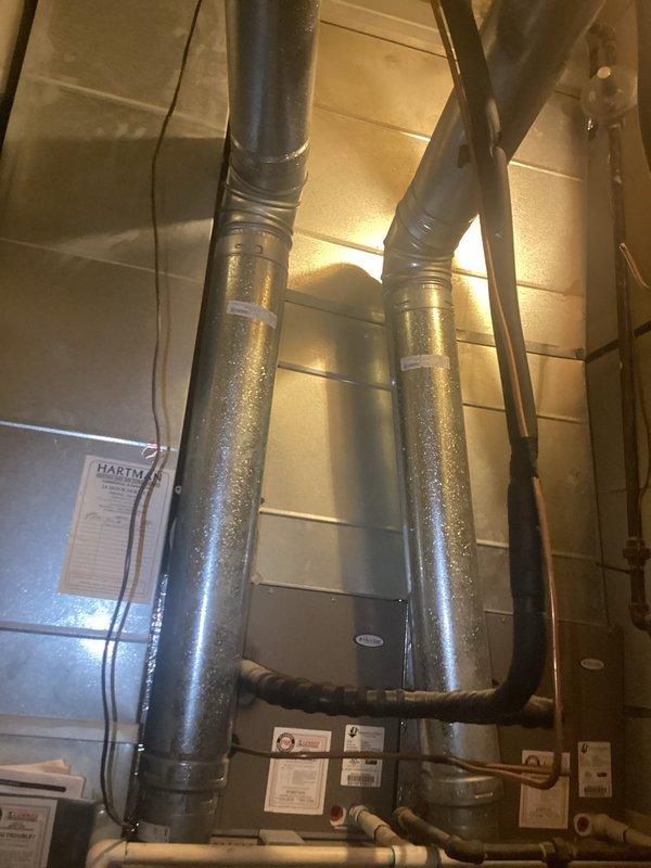 Responded to no cooling complaint on residential property with dual HVAC system configuration. Evaluated 21-year-old system with 16-year-old air conditioning components utilizing two furnaces, two 3-ton evaporator coils, and single outdoor condenser. Identified frozen evaporator coil on right system with failed metering device causing improper refrigerant flow and inadequate cooling performance. Documented moisture accumulation on ductwork and refrigerant lines indicating active system malfunction. Assessed secondary lower-level furnace system also at end of service life. Provided ballpark replacement estimates for both complete dual system replacement and single system replacement options due to age and condition of equipment beyond economical repair.