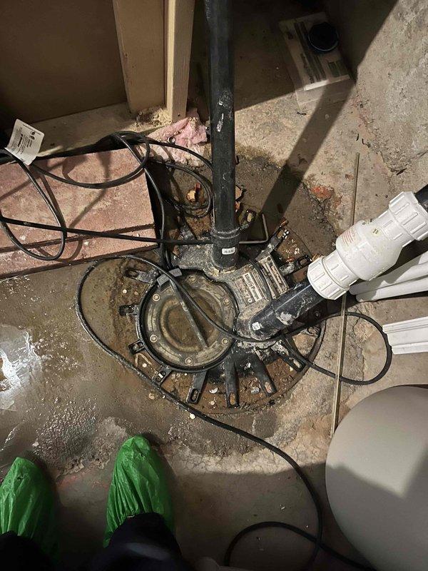 Responded to service call for toilet resealing and drain obstruction. Upon arrival, performed diagnostic evaluation of the affected fixture and drainage system. Successfully resealed toilet to eliminate leak at base connection point, ensuring proper wax ring installation and secure mounting to floor flange. Cleared drain obstruction using appropriate tools and techniques to restore full flow capacity. Inspected basement plumbing infrastructure including sump pump assembly, drainage lines, and associated piping systems to verify no additional issues were present. Noted water staining on concrete floor surrounding pump pit area, indicating previous moisture exposure. All plumbing fixtures tested and confirmed operational upon completion of repairs.