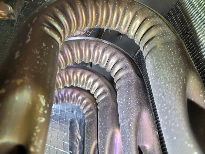 Completed preventative maintenance on 8-year-old residential air conditioning system as part of membership cooling maintenance program. Inspected evaporator coils and found normal condensation present with minor oxidation consistent with unit age; coils functioning properly with adequate airflow through finned surfaces. Examined ductwork connections and flexible transitions, noting moisture accumulation typical of normal system operation; all duct components secure with insulation intact and no visible leaks detected.