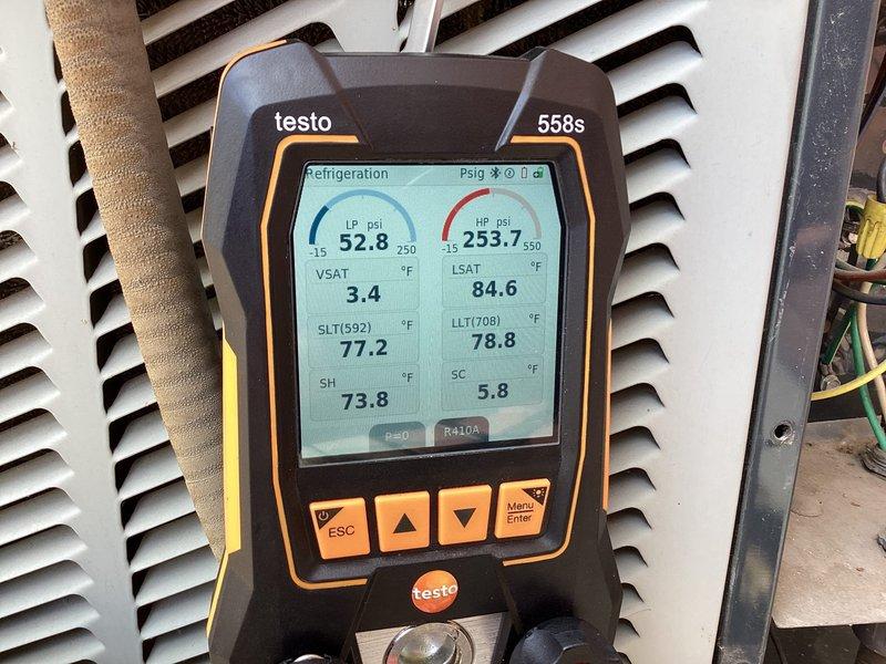 Responded to cooling complaint on second-floor unit in a two-system residential property. Upon arrival, performed comprehensive Cool 10+ maintenance service including system diagnostics with digital manifold gauges. Measured operating pressures showing low-side at 32.8 PSI and high-side at 253.7 PSI with various temperature readings ranging from 73.8°F to 84.6°F. Inspected condenser unit and refrigerant lines for reported ice formation and potential leaks, finding no active refrigerant leaks or abnormal ice accumulation at time of service. Examined indoor air handler plumbing connections and drainage components, verifying proper operation of condensate system and associated fittings. Documented system conditions with photos of internal components and diagnostic readings for service records.
