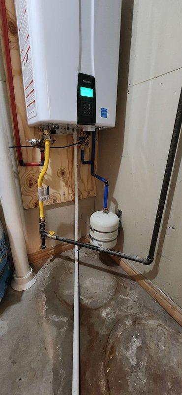 Removed two existing tanked water heaters from service, shut off water supply, drained system, and properly disposed of old units. Installed Navien NPE-240A2 tankless water heater with complete gas and water repiping to support new configuration, including 3-way service isolation valves for maintenance access. Vented exhaust through existing roof flue cap, routed condensate line to drain, and verified all connections for proper operation. Installed 64,000 grain Sentry 2 water softener on existing loop with digital control head, brine tank, and five bags of salt. Added mixing valve to reintroduce 2 grains of hardness into softened water to eliminate slippery water feel. Routed discharge line to drain and tested complete system for proper flow, temperature control, and water quality performance.