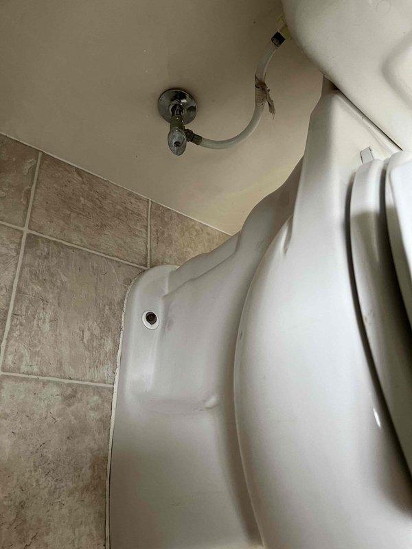 Responded to service call for malfunctioning toilet exhibiting intermittent fill valve failure and continuous running. Upon inspection, identified 16-year-old toilet with faulty fill valve assembly and deteriorating flapper mechanism causing inconsistent water flow and failure to shut off properly. Evaluated water supply line connections and shutoff valve for proper operation. Diagnosed worn internal tank components as primary cause of reported issues and documented existing plumbing conditions including copper supply piping with visible oxidation and corrosion.