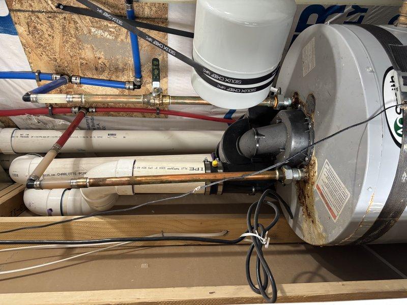 Responded to water heater leak causing basement flooding. Installed new water heater system with expansion tank, electronic circulation pump with digital display, and complete piping assembly including PEX distribution lines, copper supply connections, and PVC drain lines. Connected brass manifold valve assembly for multi-zone water distribution and wired electrical connections for pump operation. System tested and confirmed operational with no active leaks detected.