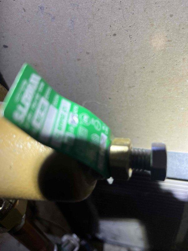 Responded to rental property for complaint of very low water pressure throughout the residence. Investigated mechanical closet and located 20+ year old pressure regulator valve exhibiting signs of internal failure and sticking operation. Confirmed inadequate downstream pressure readings consistent with failed pressure reducing valve. Documented existing brass valve assembly and copper piping configuration with photographic evidence showing corrosion on copper lines and aged valve components.