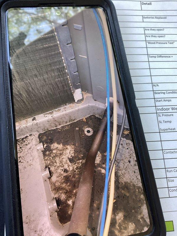 Responded to inadequate cooling complaint on basement AC unit. Upon inspection, discovered severely deteriorated evaporator coil drain pan with extensive corrosion and microbial growth, along with corroded copper refrigerant lines showing oxidation. Unit running but cooling capacity limited to 5-degree temperature drop, indicating compromised system efficiency due to component deterioration on 4-year-old equipment.