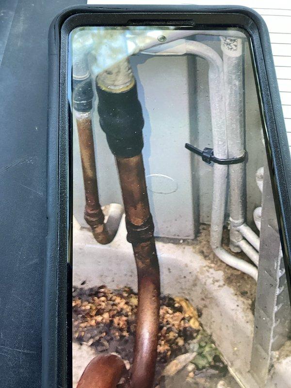 Responded to inadequate cooling complaint on basement AC unit. Upon inspection, discovered severely deteriorated evaporator coil drain pan with extensive corrosion and microbial growth, along with corroded copper refrigerant lines showing oxidation. Unit running but cooling capacity limited to 5-degree temperature drop, indicating compromised system efficiency due to component deterioration on 4-year-old equipment.