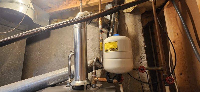 Removed failed water heater from basement utility area and installed new 50-gallon Rheem Classic water heater with all required code upgrades. Installation included new venting system with metallic flue pipe, seismic strapping for earthquake protection, temperature and pressure relief valve drop tube, gas line sediment collector, isolation valves, and flexible supply lines for both gas and water connections. Existing water softener configuration was left intact and integrated with new system. Upon completion, energized unit and conducted comprehensive leak testing on all water and gas connections, verified proper venting operation, and confirmed full functionality of heating system. All work performed under permit with inspection scheduled.