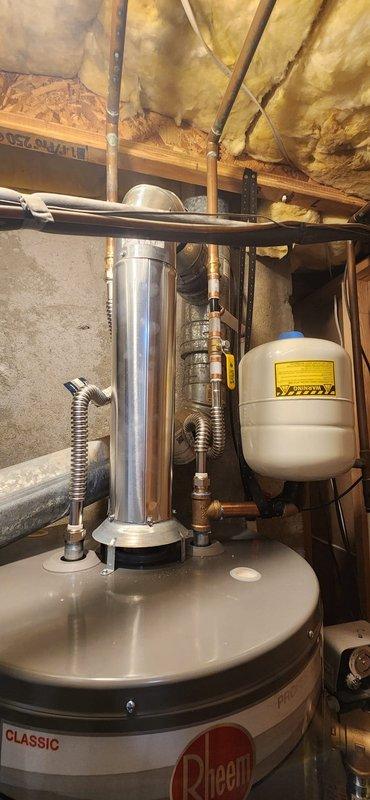 Removed failed water heater from basement utility area and installed new 50-gallon Rheem Classic water heater with all required code upgrades. Installation included new venting system with metallic flue pipe, seismic strapping for earthquake protection, temperature and pressure relief valve drop tube, gas line sediment collector, isolation valves, and flexible supply lines for both gas and water connections. Existing water softener configuration was left intact and integrated with new system. Upon completion, energized unit and conducted comprehensive leak testing on all water and gas connections, verified proper venting operation, and confirmed full functionality of heating system. All work performed under permit with inspection scheduled.