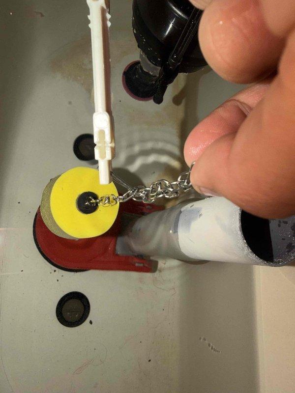 Responded to plumbing callback for toilet tank not filling and water running continuously from previous unresolved service visit. Inspected internal tank components including fill valve with red cap, flush valve assembly, and flapper mechanism. Adjusted and serviced fill valve and flapper assembly to restore proper tank filling function and eliminate continuous water flow.