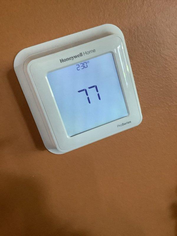 Completed routine HVAC maintenance visit including air conditioning tune-up as part of membership service. Inspected furnace closet on main floor and ground-level AC unit, verified thermostat operation showing 77°F on Honeywell Home ProSeries digital unit, and performed standard system diagnostics with temperature readings reaching 710°F during operational testing.