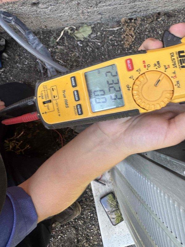 Completed Green Shield cooling maintenance on split system with furnace located in attic and condensing unit at ground level. Performed comprehensive system diagnostics using digital multimeter to test electrical components and verify proper voltage and amperage readings at the outdoor unit. Inspected condensing unit which showed significant accumulation of dirt, leaves, and organic debris on top surface and coil fins, requiring attention to maintain optimal heat transfer and system efficiency.