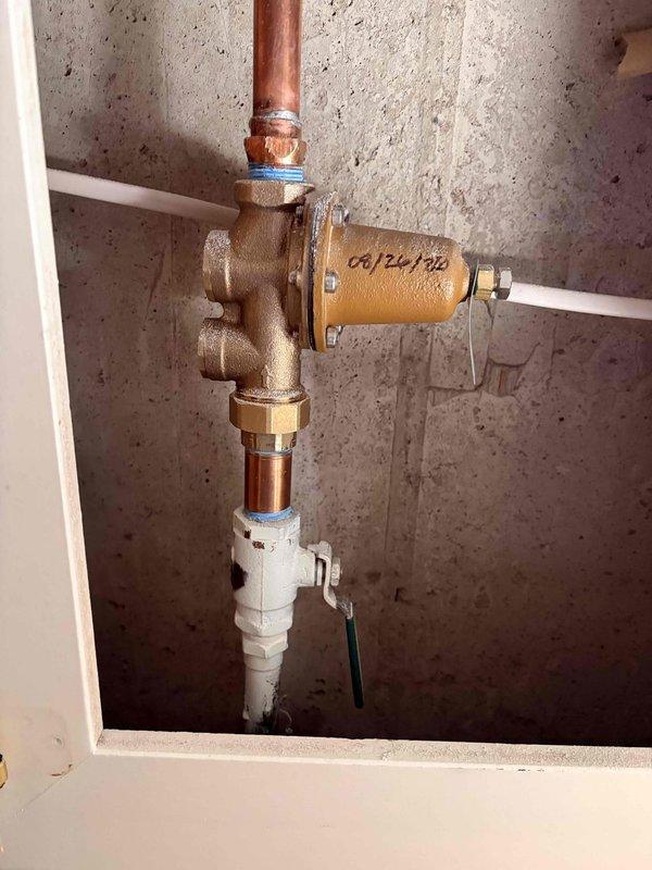 Responded to water quality complaint regarding yellowish-brown discoloration from faucets. Performed diagnostic inspection of 4-year-old water softener system installed in basement, examining control head unit displaying cleaning cycle status, plumbing connections, and overall system operation. Documented system condition including copper and PEX supply lines, brass fittings, control valve assembly, and resin tank to determine cause of water discoloration issue.