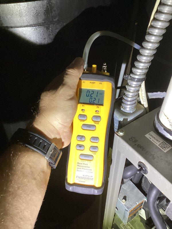 Completed comprehensive membership maintenance including A/C tune-up with outdoor condenser unit located in backyard and furnace system in basement. Verified system pressures using digital manometer showing 0.21" readings, confirmed proper electrical supply at outdoor disconnect measuring 238 volts with multimeter. Inspected furnace filter condition per customer request and provided replacement filter for future use when due for change.
