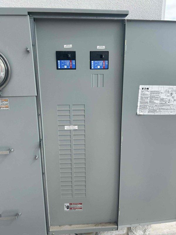 Completed comprehensive Green Shield electrical inspection of outdoor main electrical service panel. Inspected Eaton-branded electrical distribution equipment including dual digital display meters with blue backlighting showing proper operational readouts. Verified ventilation louvers functioning correctly, confirmed all panel mounting hardware secure, and ensured all warning labels properly affixed and legible. Documented panel condition with photos showing all components in clean, functional condition with no visible damage or safety concerns.