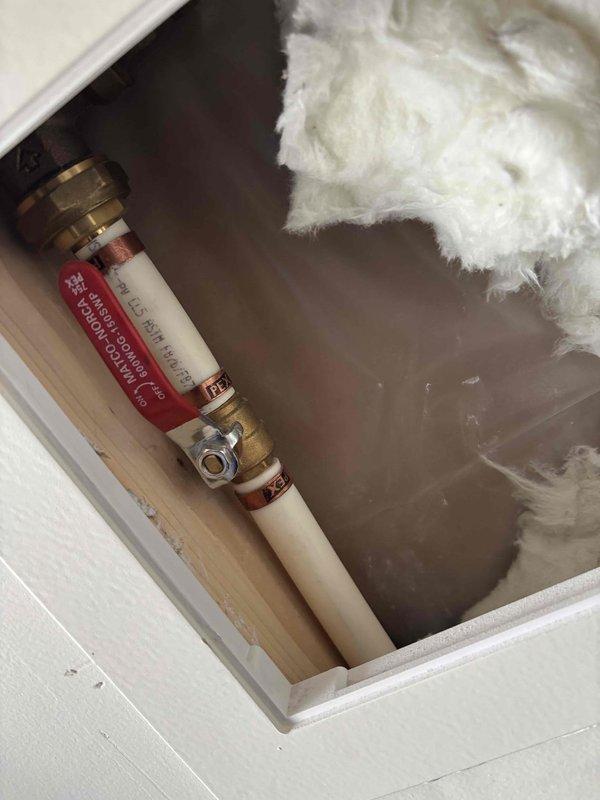 Completed comprehensive plumbing membership inspection including evaluation of 16-year-old tanked water heater located in garage. Inspected water heater compartment, noting standing water accumulation in access area with visible PVC piping and brass fittings. Tested and documented static water pressure at hose bib using calibrated pressure gauge, verifying system pressure levels within operational parameters.