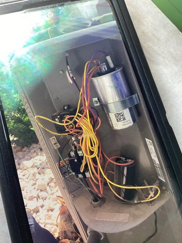 Completed comprehensive air conditioning tune-up and preventative maintenance inspection for residential split system. Performed visual inspection of outdoor condensing unit including heat pump with oval fan grille and cylindrical condenser coil. Inspected electrical control panel, verified capacitor connections and integrity, checked contactor operation, and examined all wire terminations for proper connection and no signs of overheating. Verified system mounted on decorative rock base with adequate clearance for airflow. All components operating within normal parameters upon completion of maintenance service.