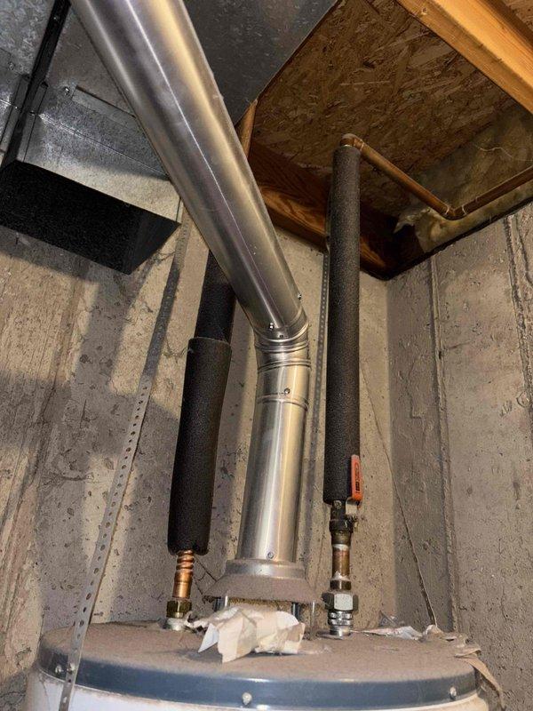 Responded to a no hot water call for a 6+ year old Rheem Guardian Fury tank-style water heater located in the basement. Diagnosed pilot light failure where pilot would not remain lit after ignition, indicating a faulty thermocouple or gas control valve issue. Inspected unit, confirmed proper venting and gas supply connections, and documented existing installation with black foam pipe insulation on water lines and standard exhaust configuration.